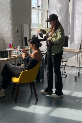 Gigi styling a client’s hair at a studio set.