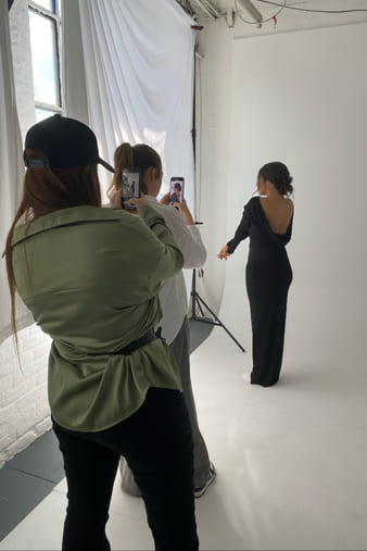 Behind the scenes: a styled client being photographed in the studio.