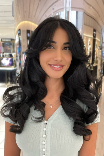 Client with a curly blow-dry on long black type 2B hair.
